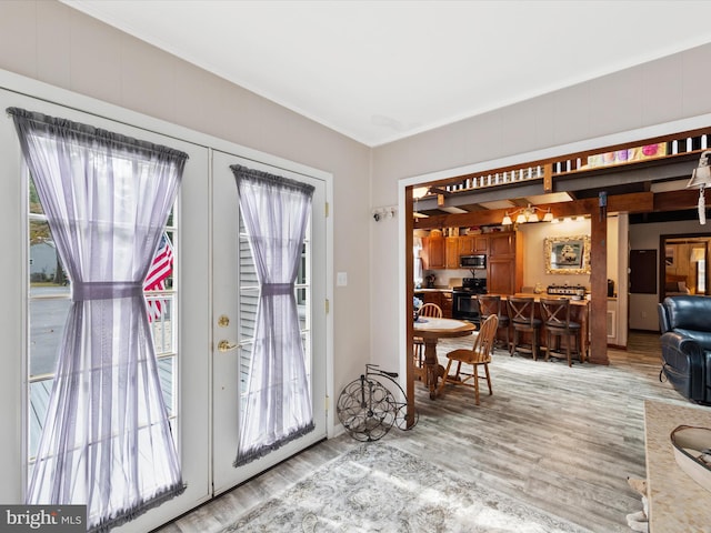 doorway featuring a healthy amount of sunlight, french doors, and light hardwood / wood-style flooring