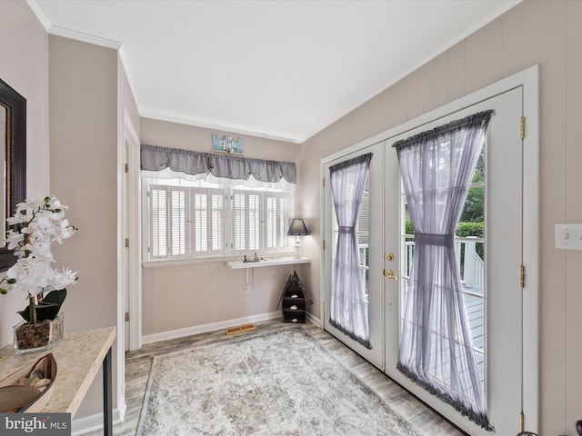 doorway with french doors, crown molding, and hardwood / wood-style floors