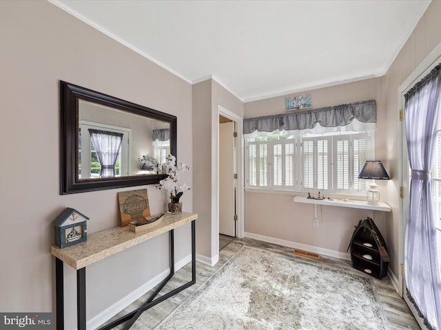 interior space with crown molding and light hardwood / wood-style flooring