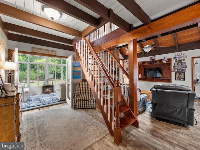 stairway with ceiling fan, beam ceiling, wood ceiling, and wood-type flooring