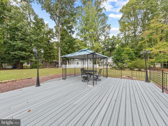 wooden deck featuring a gazebo and a lawn