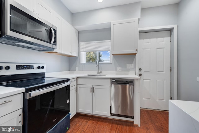 kitchen featuring dark wood-type flooring, stainless steel appliances, sink, and white cabinets