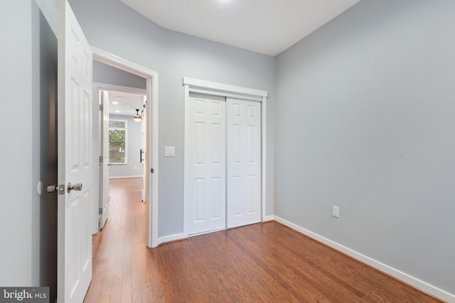 unfurnished bedroom with hardwood / wood-style flooring and a closet