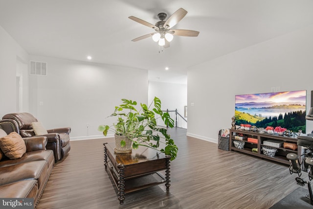 living room featuring ceiling fan and dark hardwood / wood-style floors