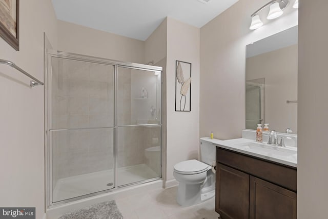 bathroom with vanity, toilet, tile patterned flooring, and a shower with door