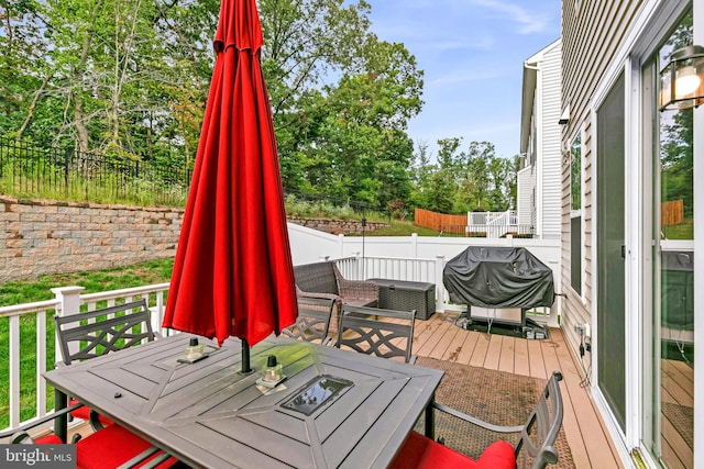 wooden deck with an outdoor living space and area for grilling