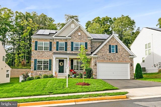 view of front of home with a garage, a front lawn, and solar panels