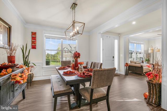 dining space featuring ornamental molding, an inviting chandelier, dark hardwood / wood-style floors, and plenty of natural light