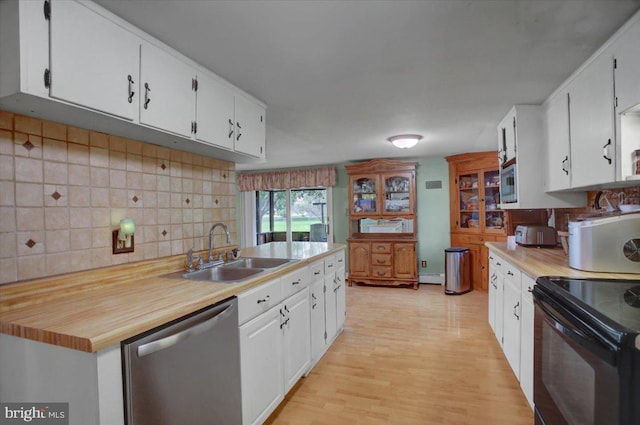 kitchen featuring sink, white cabinetry, appliances with stainless steel finishes, light hardwood / wood-style floors, and decorative backsplash