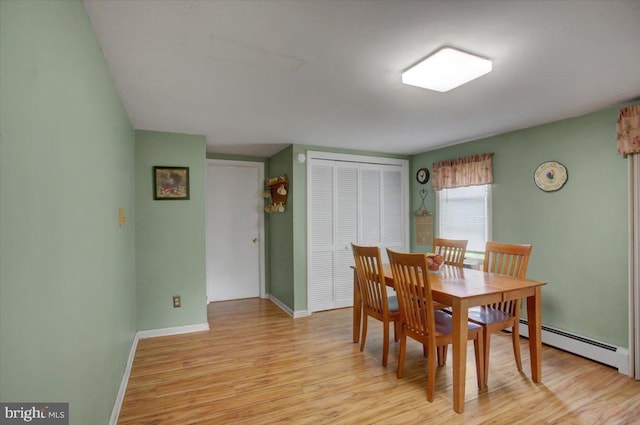 dining room featuring baseboard heating and light hardwood / wood-style flooring