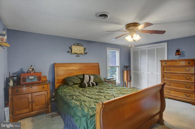 bedroom featuring a closet, light colored carpet, and ceiling fan