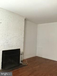 unfurnished living room with dark wood-type flooring