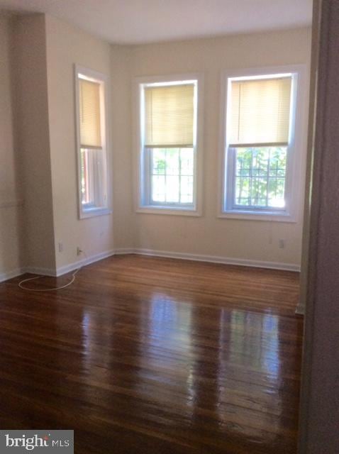 spare room featuring dark hardwood / wood-style flooring and a wealth of natural light