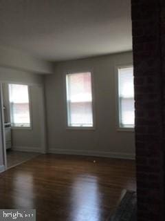 spare room with dark wood-type flooring