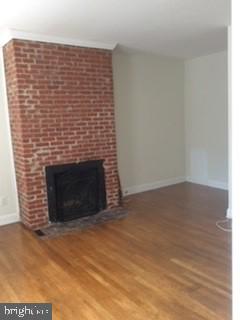 unfurnished living room with hardwood / wood-style flooring and a fireplace