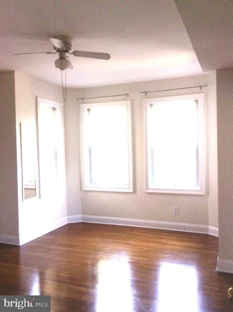 empty room featuring ceiling fan and dark wood-type flooring