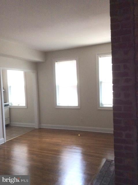 empty room with dark hardwood / wood-style flooring