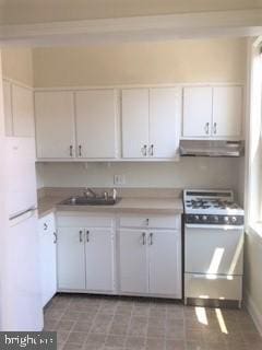 kitchen with white cabinets, white appliances, and sink