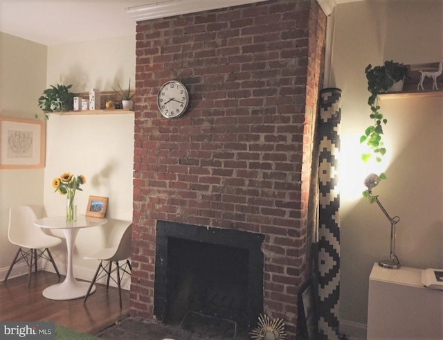 interior details featuring a brick fireplace and hardwood / wood-style floors