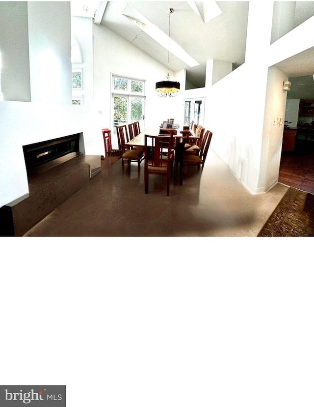 dining room with a fireplace, high vaulted ceiling, and a skylight