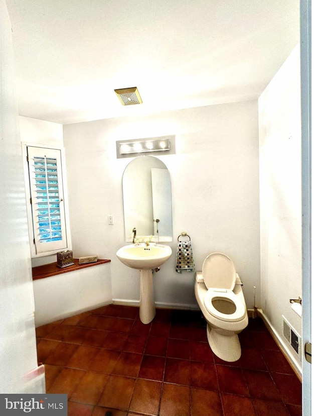 half bathroom with tile patterned floors, visible vents, and toilet