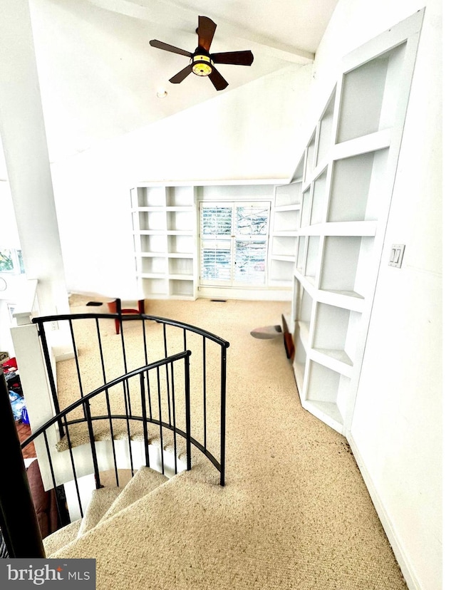 staircase with a ceiling fan, vaulted ceiling, carpet floors, and baseboards
