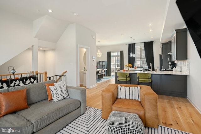 living room with light hardwood / wood-style flooring and an inviting chandelier