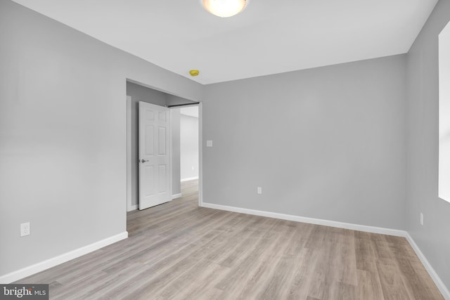 unfurnished room with light wood-style floors and baseboards