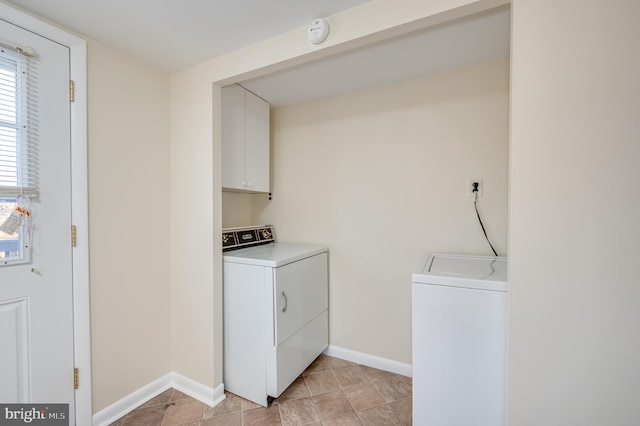 laundry area featuring washer and dryer, cabinets, and light tile patterned floors