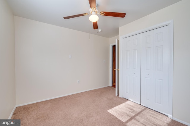 unfurnished bedroom with light carpet, a closet, and ceiling fan