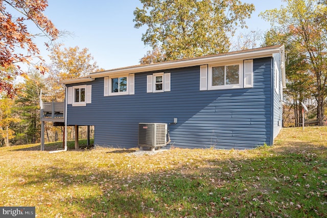 view of side of property featuring a yard and central AC unit