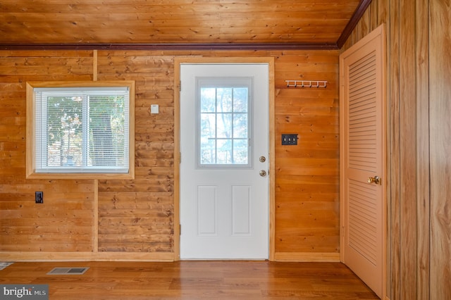 doorway to outside with hardwood / wood-style floors, wooden walls, and wooden ceiling