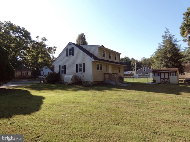 back of house featuring a yard and a storage shed