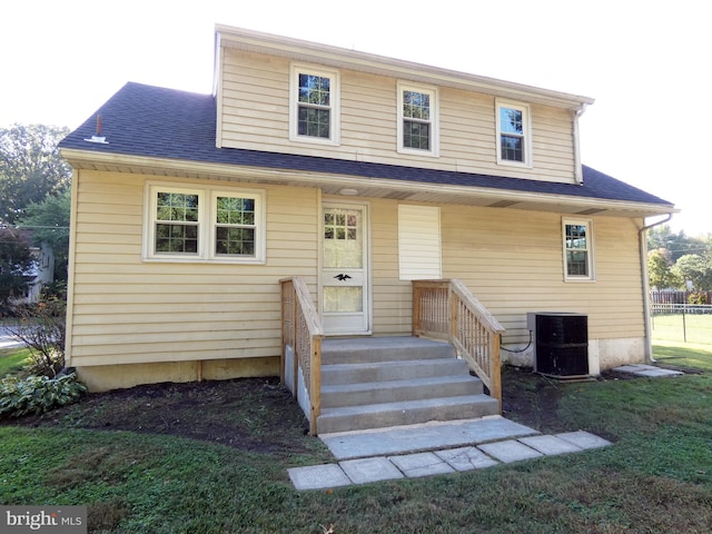 view of front of property featuring a front yard and central air condition unit