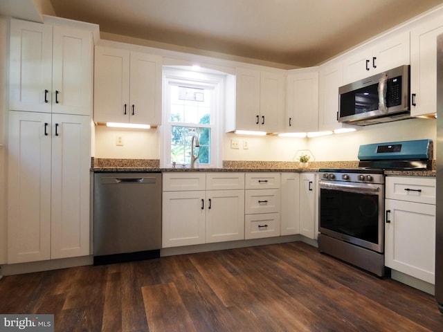 kitchen featuring white cabinetry, stainless steel appliances, and dark wood-type flooring