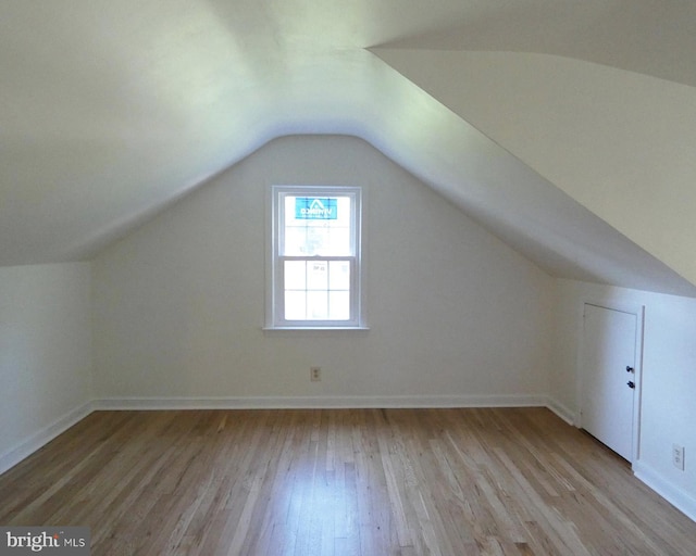 additional living space featuring light hardwood / wood-style flooring and lofted ceiling