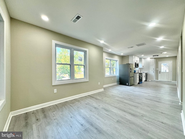 unfurnished living room with light wood-type flooring and sink