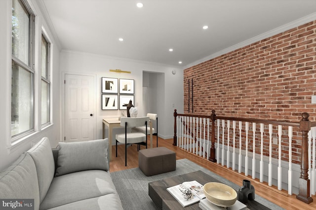 living room with brick wall, hardwood / wood-style flooring, and crown molding