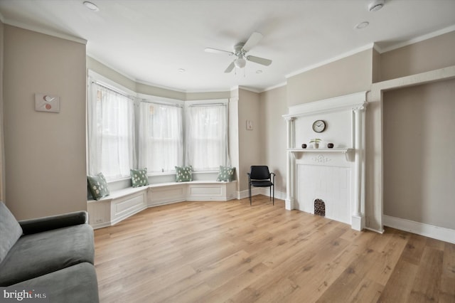 living room with light wood-type flooring, ceiling fan, and crown molding