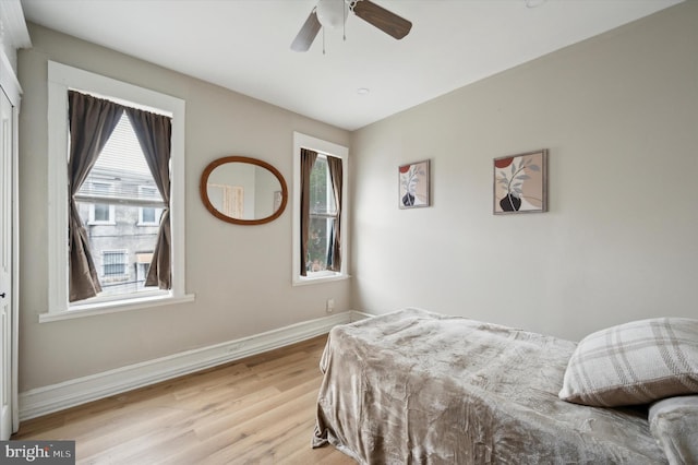 bedroom featuring light hardwood / wood-style floors, multiple windows, and ceiling fan