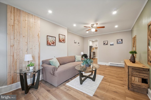 living room featuring ceiling fan, baseboard heating, light wood-type flooring, and ornamental molding