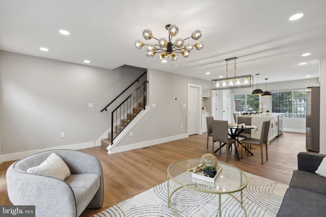 living room with light hardwood / wood-style flooring and a notable chandelier