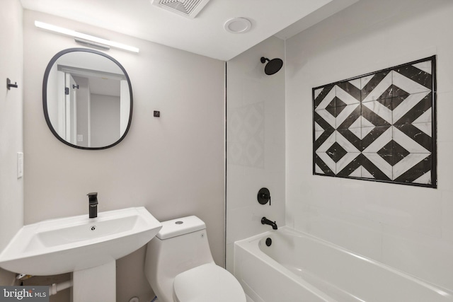 full bathroom with sink, tiled shower / bath combo, and toilet