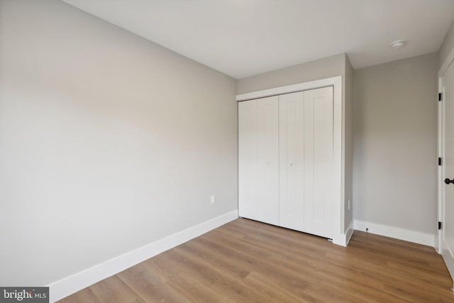 unfurnished bedroom with a closet and hardwood / wood-style flooring