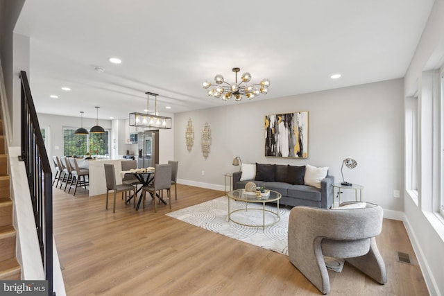 living room with a notable chandelier and light hardwood / wood-style flooring