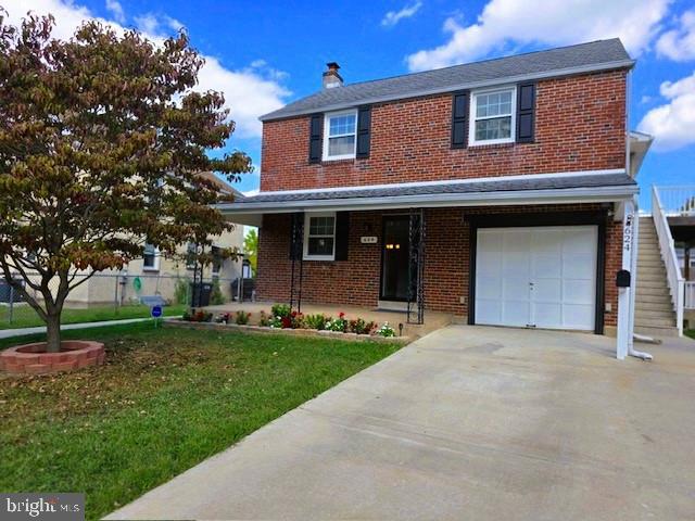 view of front of home with a front lawn and a garage