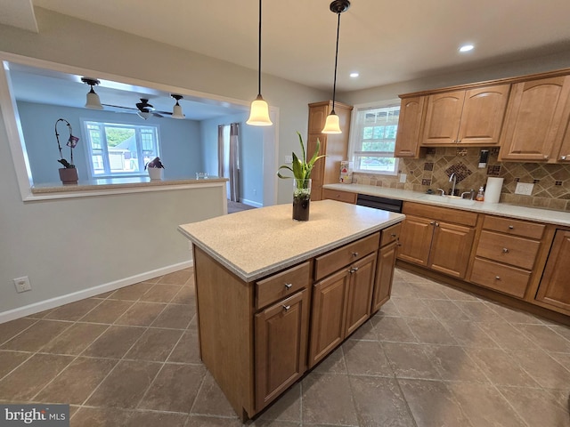 kitchen featuring decorative backsplash, hanging light fixtures, a healthy amount of sunlight, and a kitchen island