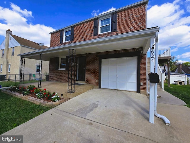 view of front of home featuring a garage, covered porch, and central AC