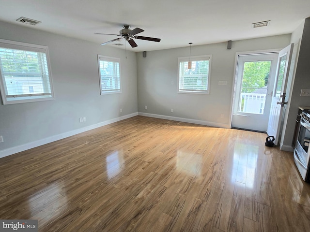 unfurnished room featuring ceiling fan, a healthy amount of sunlight, and light hardwood / wood-style flooring