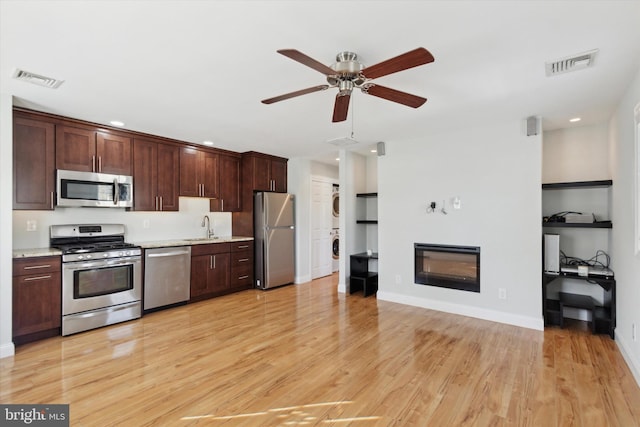 kitchen featuring stainless steel appliances, light hardwood / wood-style floors, sink, ceiling fan, and built in features